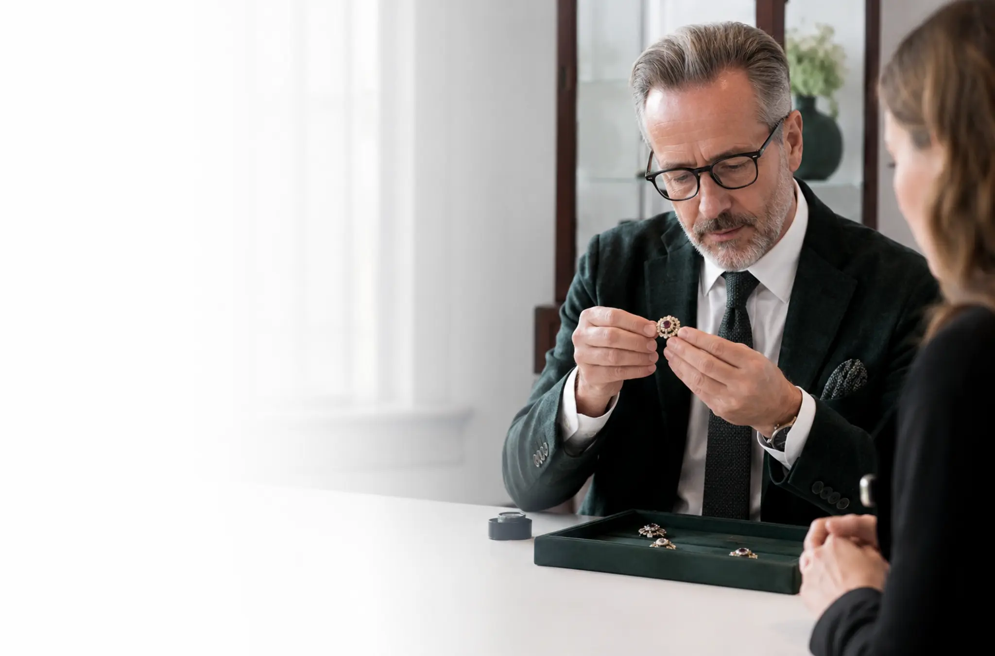 Sfeerbeeld van een juwelenexpert die samen met een klant een juweel bekijkt